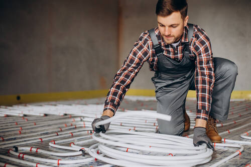 Service man instelling house heating system floor